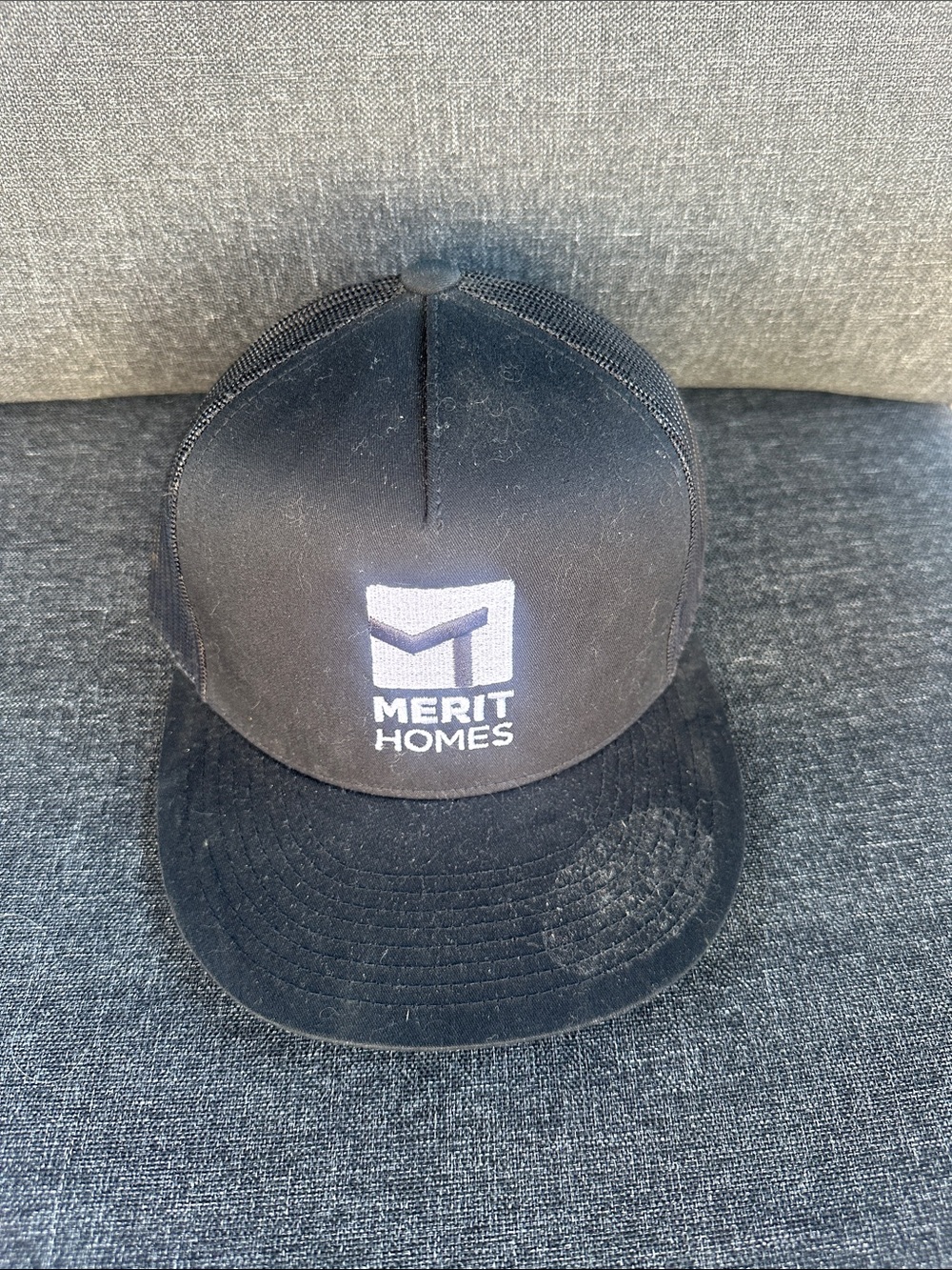 The Classic Black Merit Homes Logo Trucker Hat